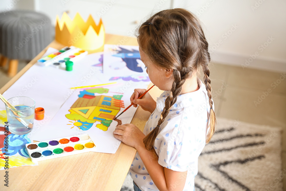 Little girl painting with brush at home