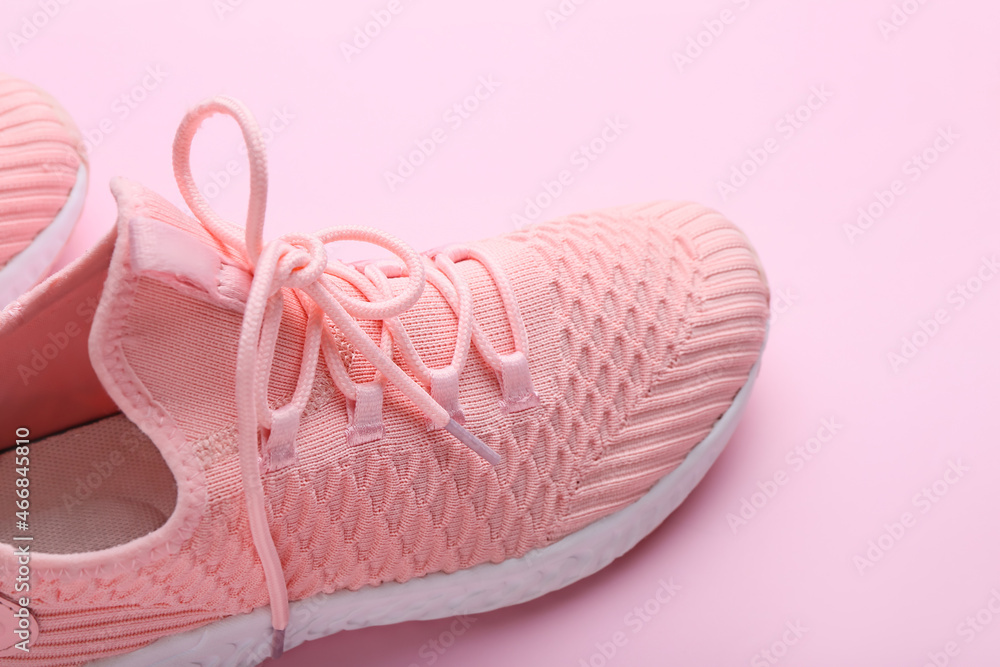 Sportive shoes on pink background, closeup