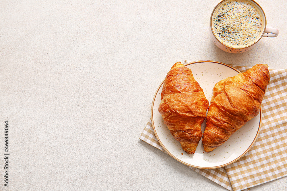 Plate with delicious croissants and cup of coffee on white background