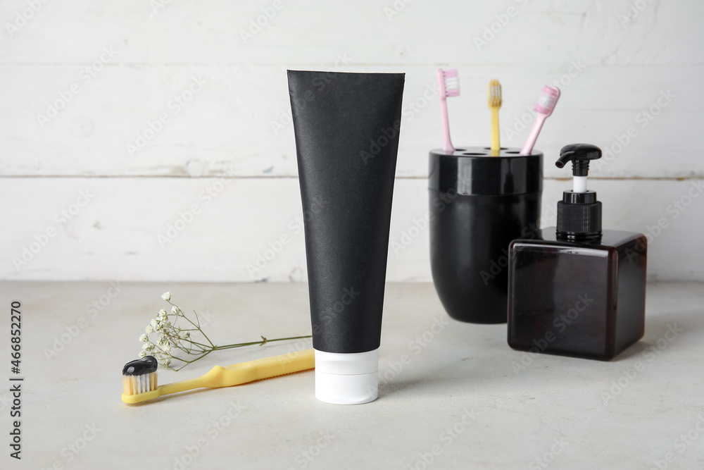 Black toothpaste with activated carbon and set for oral hygiene on table