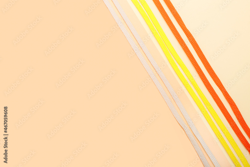 Different shoe laces on color background, closeup