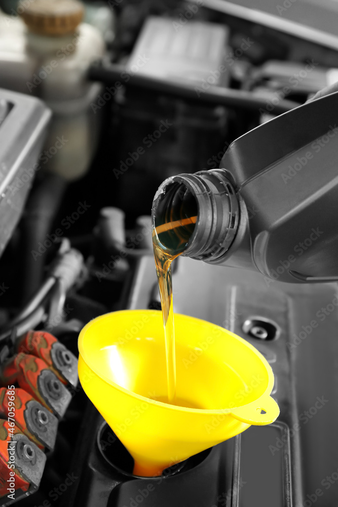 Pouring of motor oil from canister into car engine