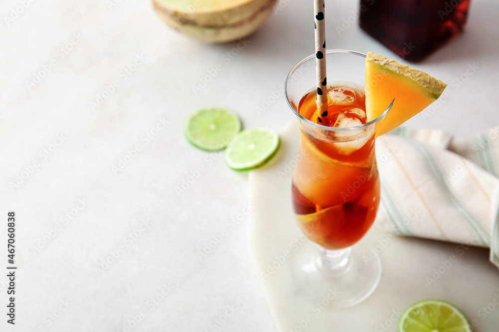 Glass with melon cocktail on light background