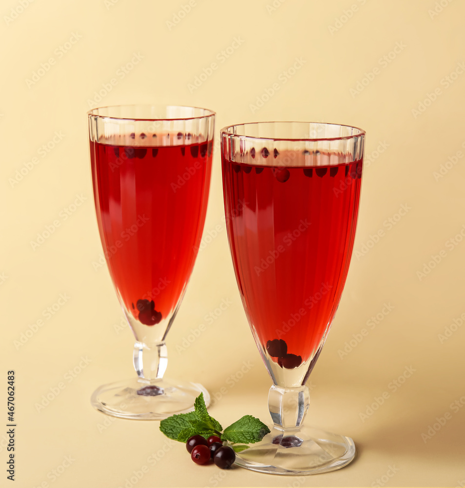 Glasses with healthy cranberry juice on color background