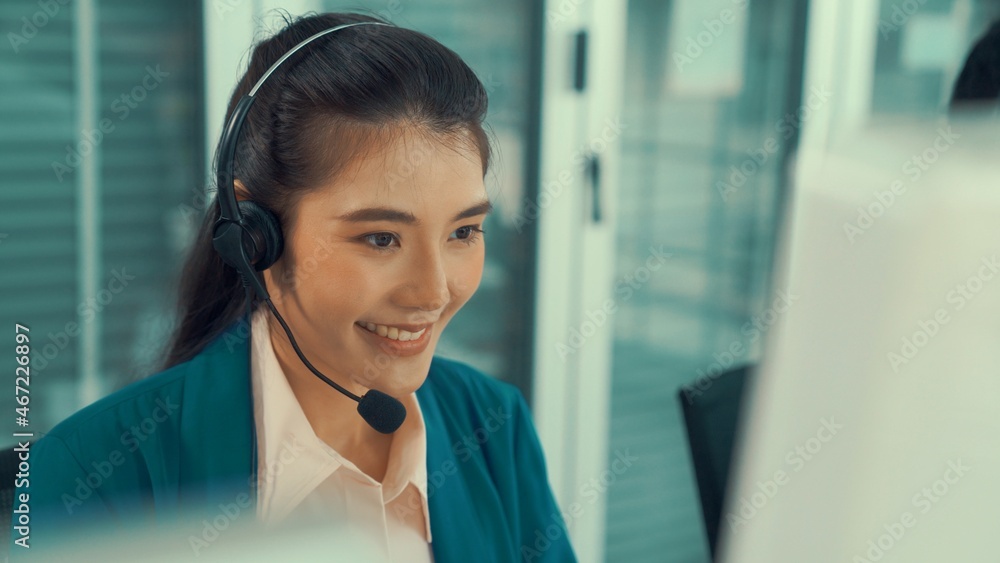 Businesswoman wearing headset working actively in office . Call center, telemarketing, customer supp