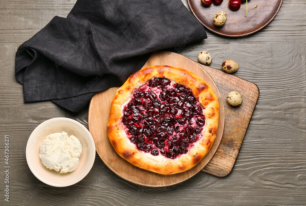 Plate with tasty cherry khachapuri, cottage cheese and quail eggs on wooden background