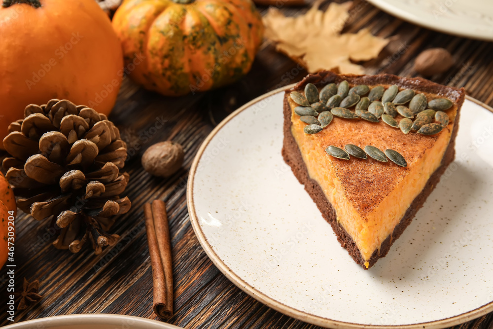 Piece of delicious pumpkin pie on wooden background