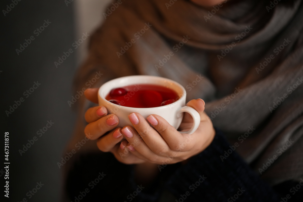 Young woman drinking tea in cafe, closeup