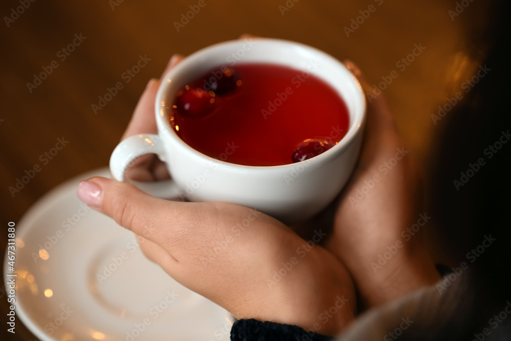 年轻女子在咖啡馆的餐桌上喝茶