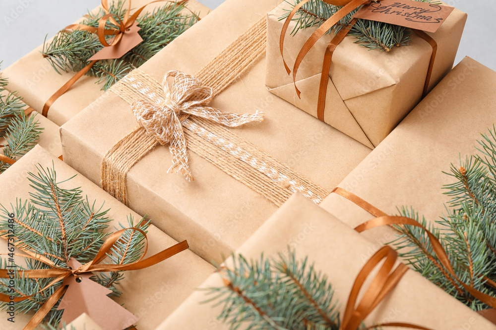 Christmas presents with fir branches on light background