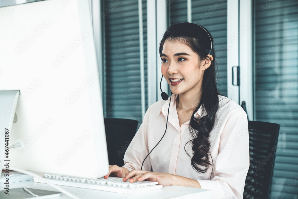 Businesswoman wearing headset working actively in office . Call center, telemarketing, customer supp