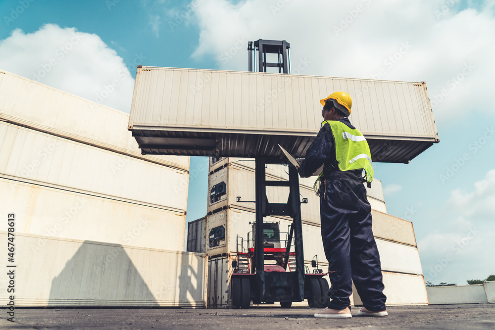 Young African American woman worker at overseas shipping container yard . Logistics supply chain man