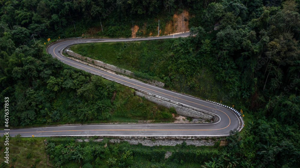 绿色森林的山口沥青公路鸟瞰图，穿过山谷的乡村公路