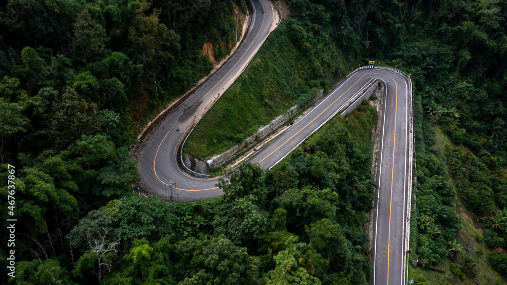 绿色森林的山口沥青公路鸟瞰图，穿过峡谷的乡村公路