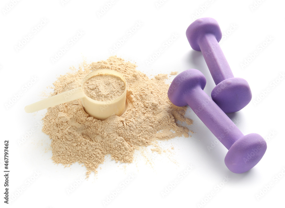 Measuring scoop with protein powder and dumbbells on white background