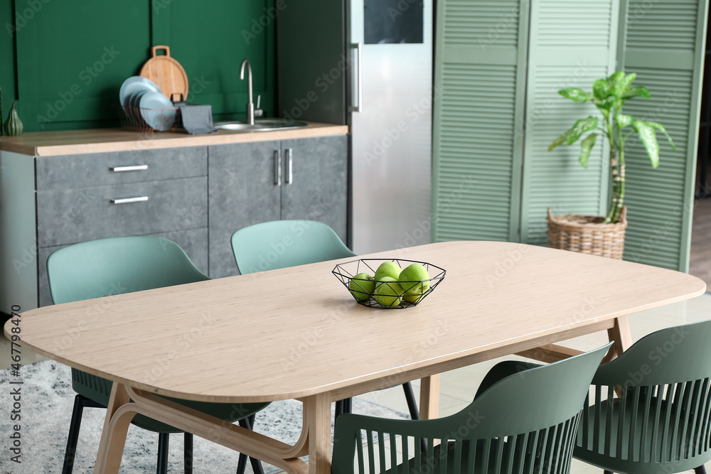 Dining table with green apples in stylish kitchen