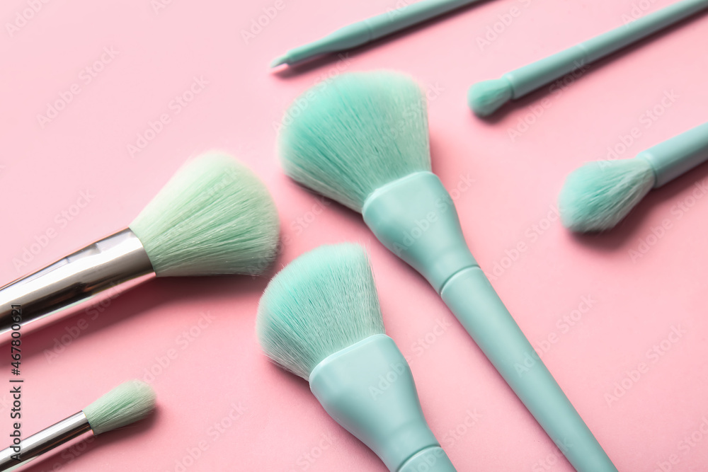 Set of stylish makeup brushes on pink background, closeup