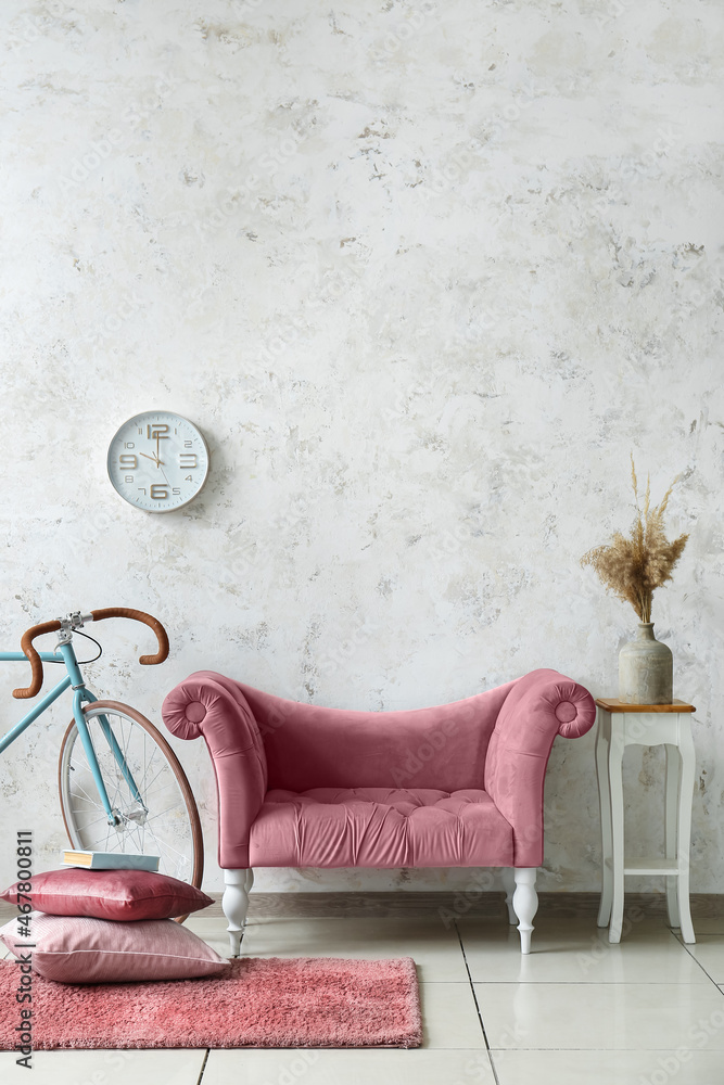 Interior of light living room with pink sofa and bicycle