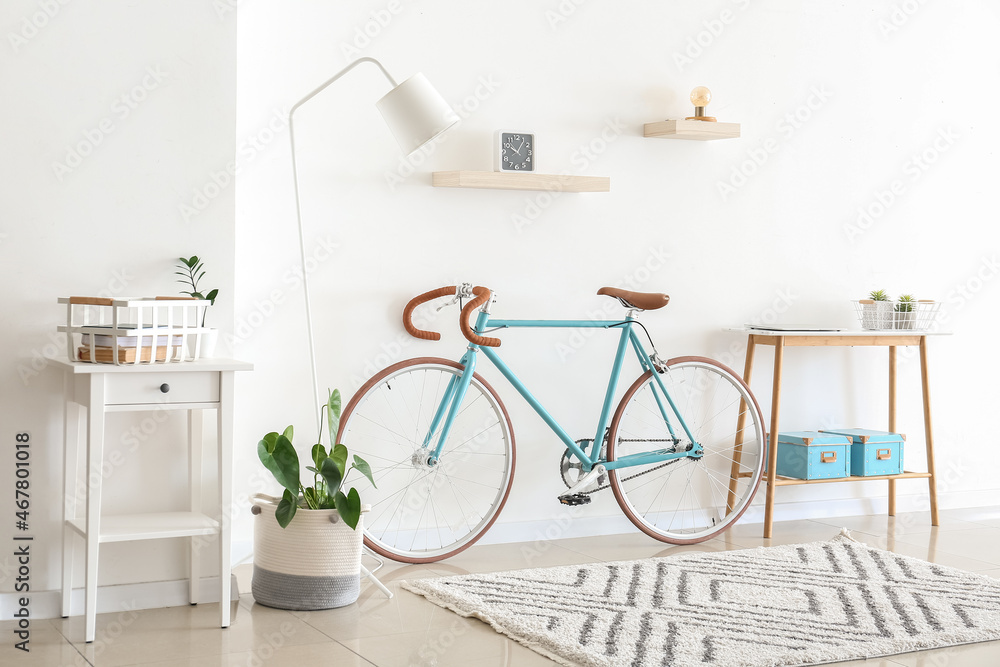 Interior of light living room with bicycle and table