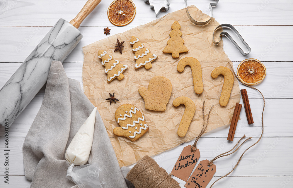 Composition with Christmas gingerbread cookies and spices on light wooden background