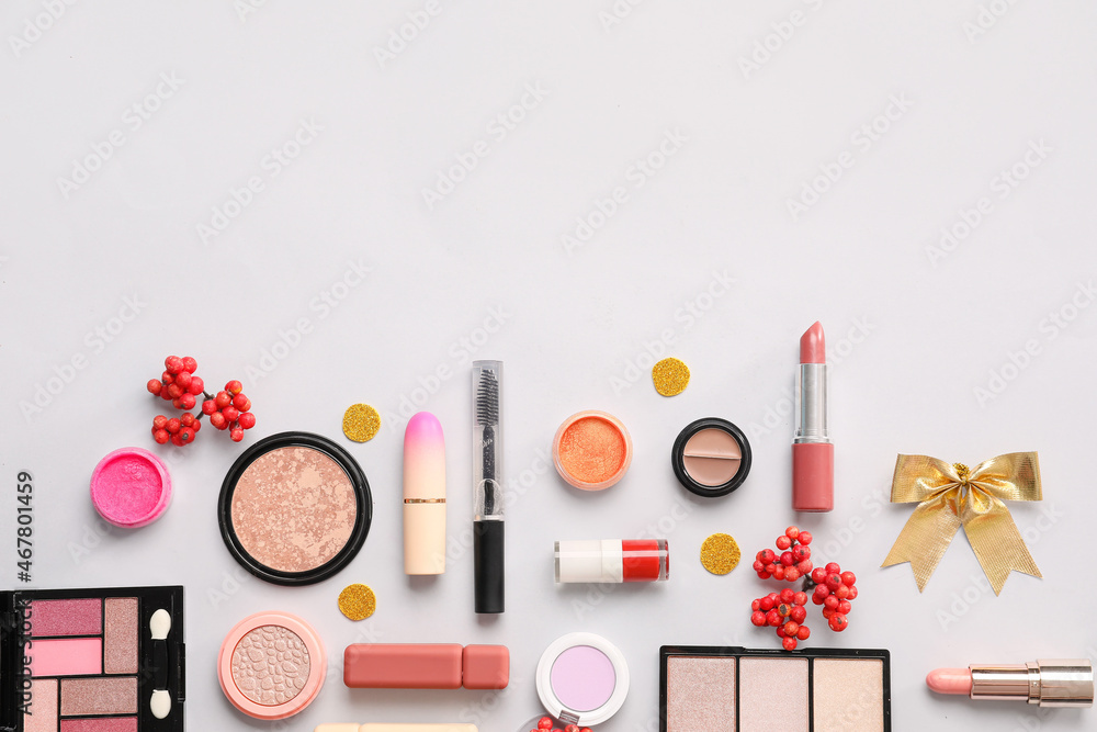 Beautiful composition with makeup cosmetics and Christmas decor on light background