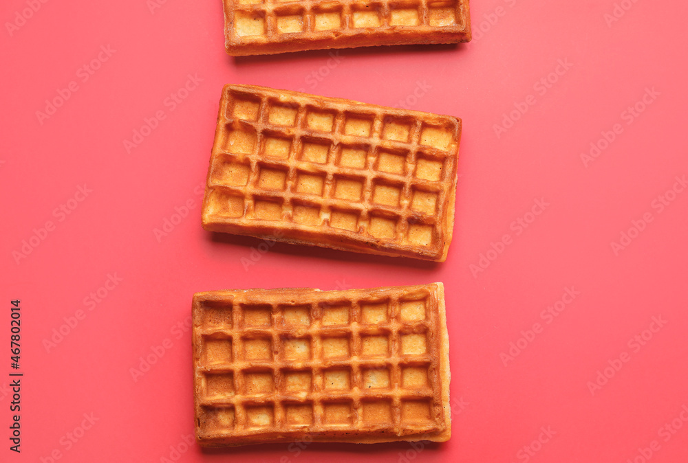 Delicious golden Belgian waffles on color background