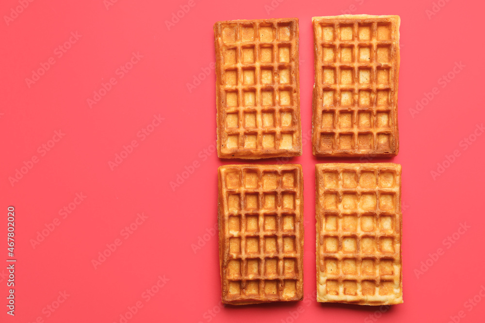 Tasty golden Belgian waffles on color background