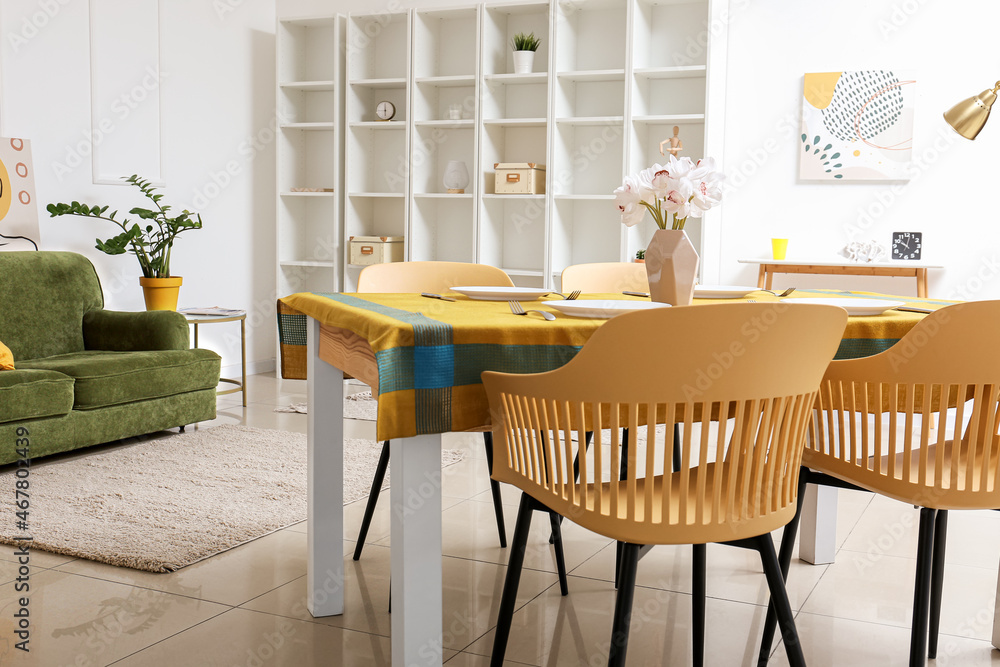 Interior of modern dining room with table, chairs and shelving unit