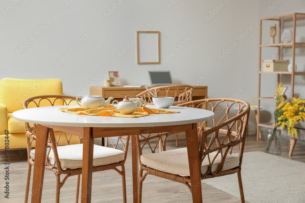 Dining table with wicker chairs in modern room