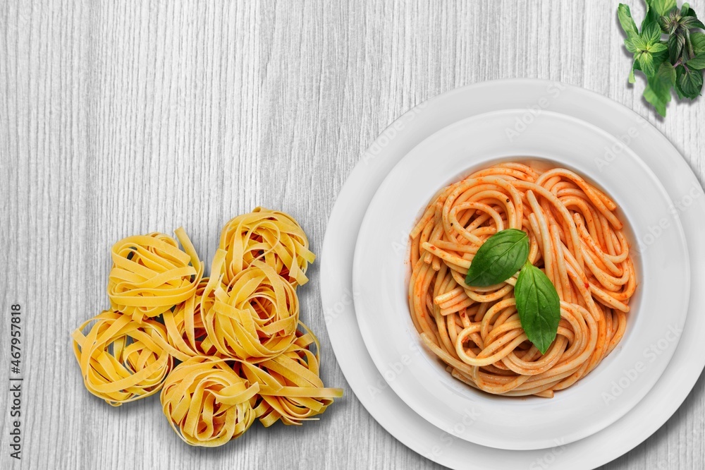 Tasty pasta dish with tomato sauce and cheese on the desk