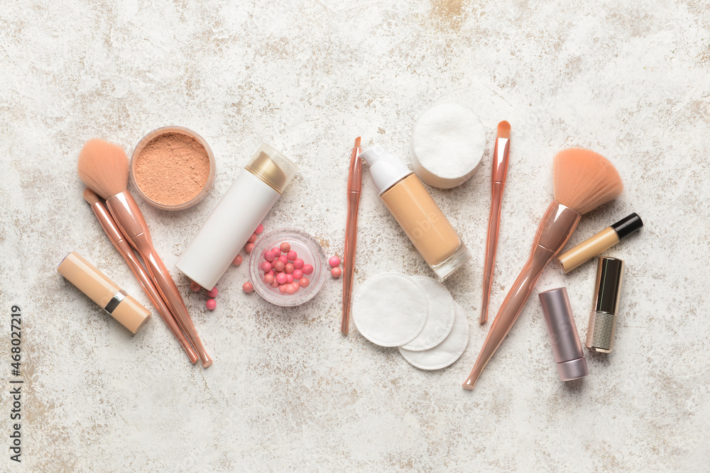 Different decorative cosmetics, brushes and cotton pads on light background