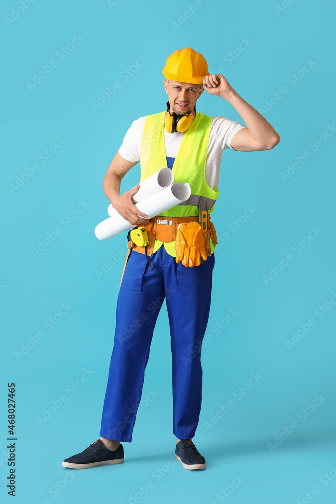 Male builder with drawings on color background