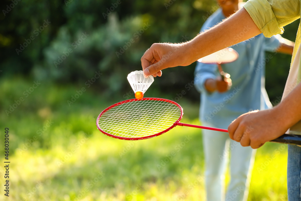 Young men playing badminton  outdoors