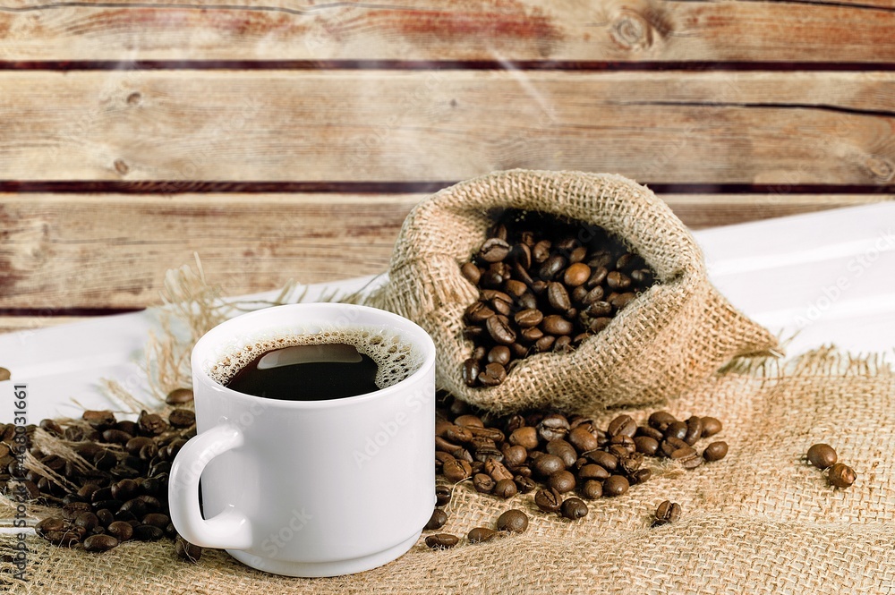 Coffee beans with a cup of hot coffee on wooden desk