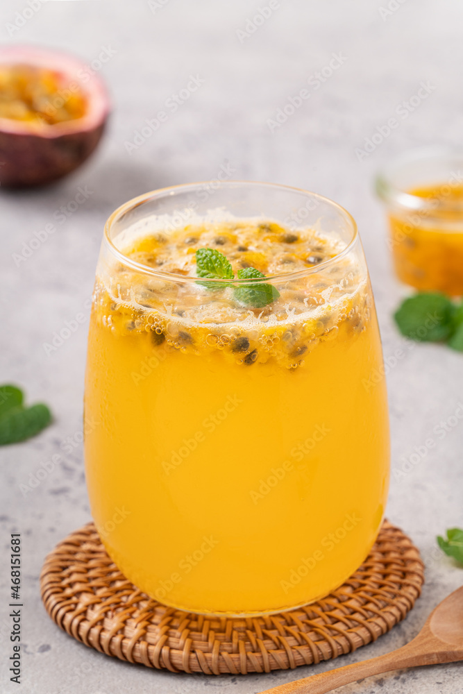 Delicious juicy passion fruit with sparkling juice on gray table background.