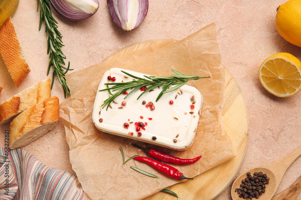 Board with tasty feta cheese and spices on color background