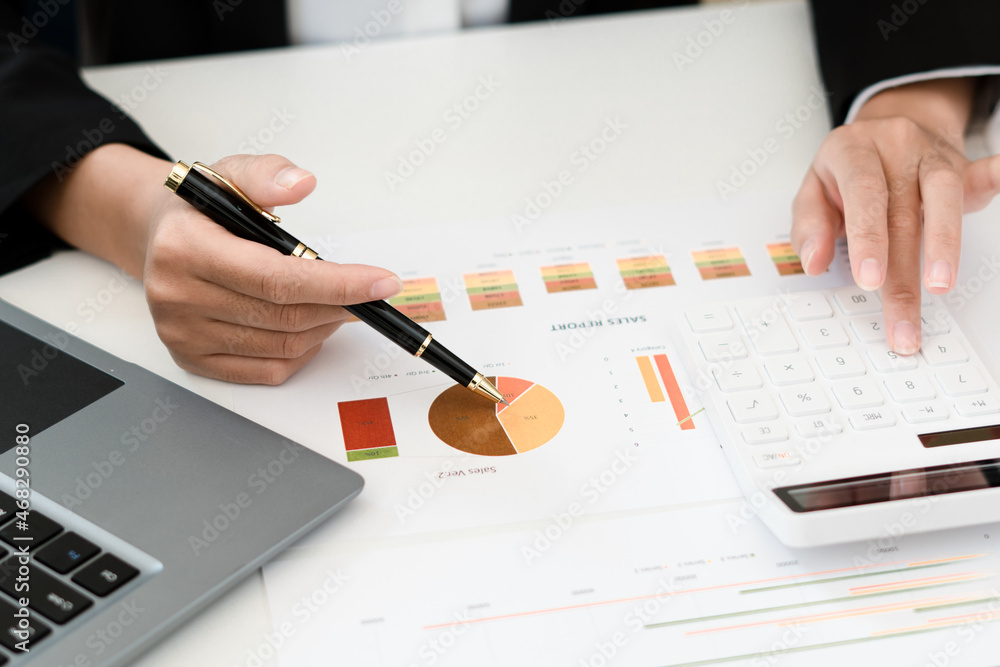 Businessman pen pointing turnover with graph chart report and use laptop computer for analysis data