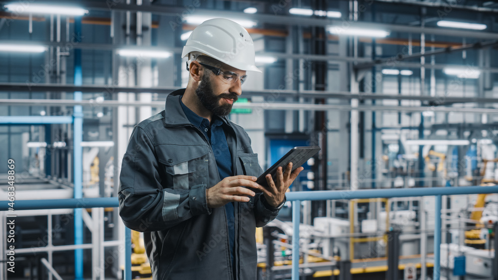 Car Factory Engineer in Work Uniform Using Tablet Computer. Automotive Industry 4.0 Manufacturing Fa