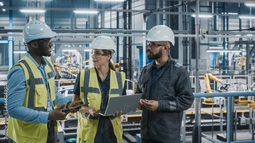 Young Diverse Team of Car Factory Specialists Working on Laptop and Tablet Computers. Engineers Disc