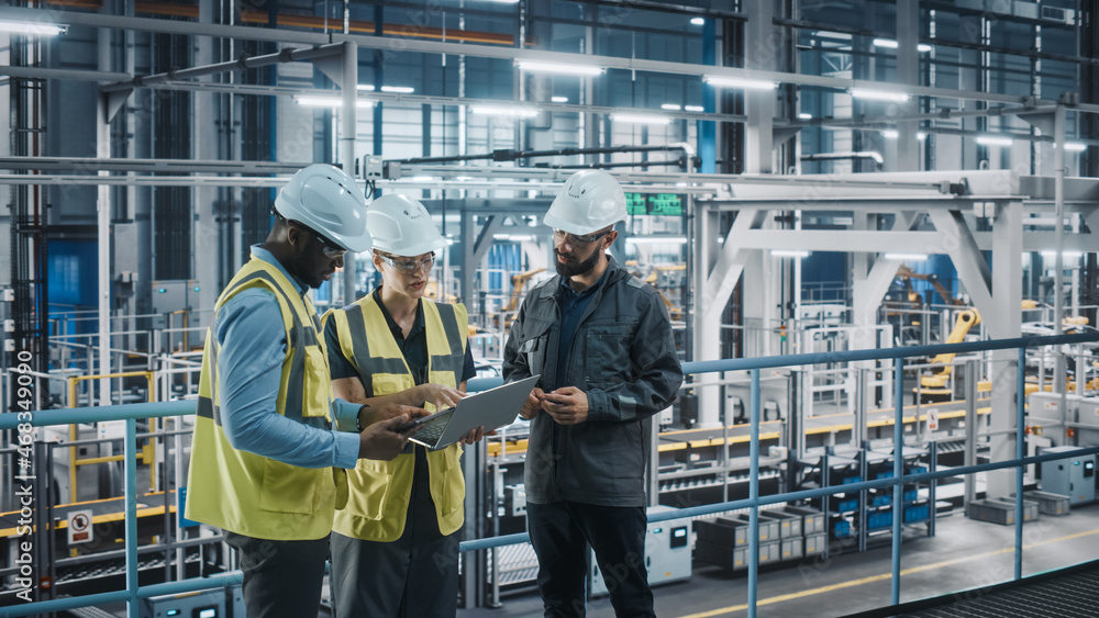 Young Diverse Team of Car Factory Specialists Working on Laptop and Tablet Computers. Engineers Disc