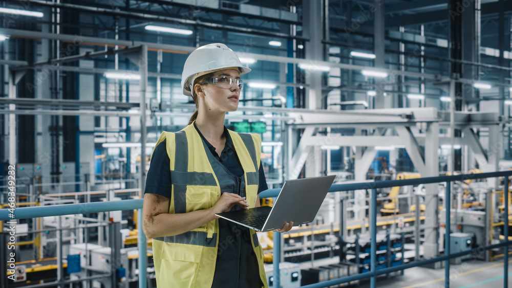 Portrait of Female Automotive Industry 4.0 Engineer in Safety Uniform Using Laptop at Car Factory Fa