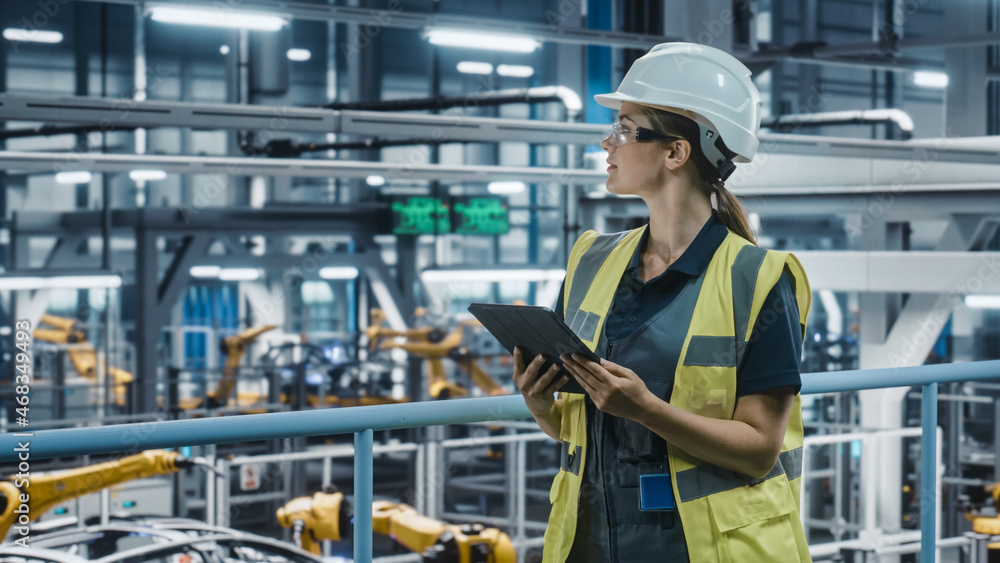 Female Car Factory Engineer in High Visibility Vest Using Tablet Computer. Automotive Industrial Man