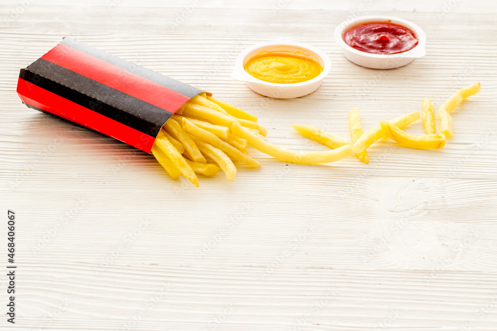 French fries in red paper wrapper with different sauces