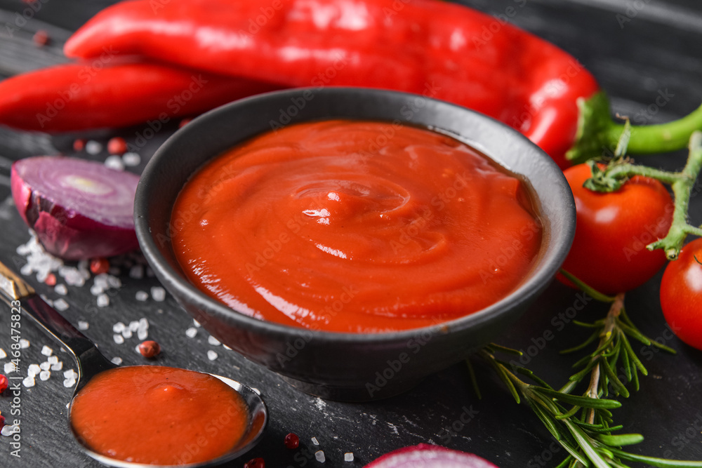 Bowl with organic tomato sauce on table