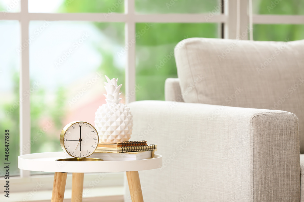 Interior of stylish living room with sofa and alarm clock