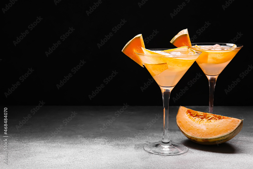 Glasses of tasty melon cocktail on dark background