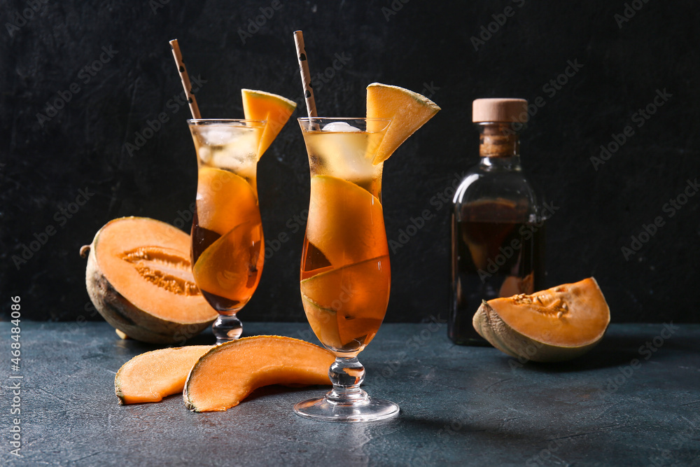 Glasses with delicious melon cocktail on dark background