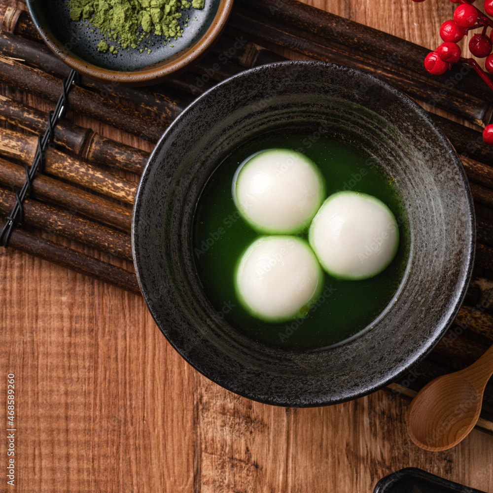 Matcha big tangyuan and matcha soup on wooden table.