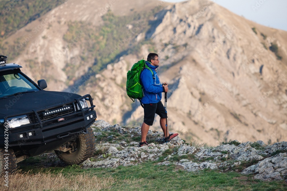 Man with backpack hiking up adventure mountain