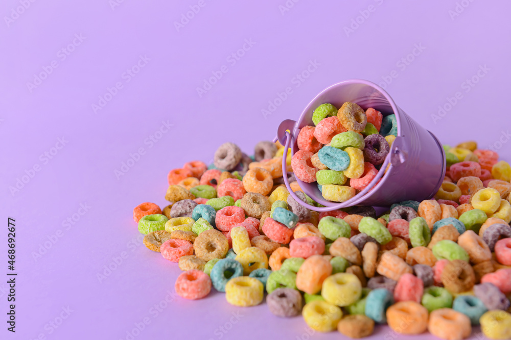 Small bucket with crunchy corn flakes rings on color background